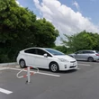 Ledönthető kengyel alakú parkolásgátlóval védett parkolóhely egy fehér toyota prius mellett