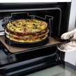 négy darab pizzasütő tálcát és egy darab acél állványt tartalmazó pizzakészítő készlet három darab éppen elkészült pizzával a sütőben