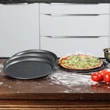Perforált pizzasütő tálca készlet négy darab elemmel a konhyapulton éppen pizzkészítés közben