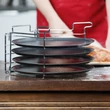 Pizzasütő állvány 4 darab pizzasütő tálcával a konyhapulton pizzakészítés közben