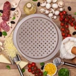 Barna színű pizzakészítő sütőforma a konyhapulton körben feltétekkel