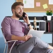 Telefonáló férfi háttérben egy fekete színű Hogan íróasztallal