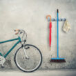 Bicikli mellett a garázsban elhelyezett falra szerelhető kerti eszköz és szerszámtartó