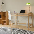 A nappali egyik sarkában elhelyezett nagyméretű bambusz írósztal és számítógépasztal laptoppal és minimal design székkel