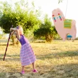 Pink alpaca pinatát szétverő kislány a szabadban 