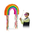 Szivárvány formájú színes pinata jobb oldalon egy bekötött szemű kis sráccal