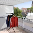 Nagyméretű napos teraszon elhelyezett összecsukható ruhaszárító állvány ingekkel