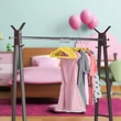 Ruhatartó állványon a gyerekszobában elhelyezett gyermek ruhák sárga plüss borítású gyerek vállfákon