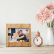 Bambusz álló képkeret egy darab fényképnek mellette egy vázával és egy órával
