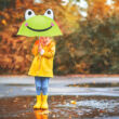 Esőben álldogáló kislány kezében egy béke mintás gyerek esernyő 3d-s szemekkel