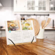 Fa konyhapulton elhelyezett rivka szakácskönyvtartó állvány kinyitott szakácskönyvvel