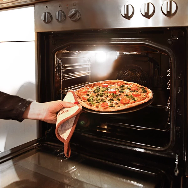 pizza tálca és sütőforma használat közben a sütőből éppen kivéve