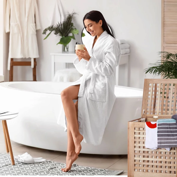 Modern letisztult fürdőszoba egyik sarkába állított lion diófa szennyestartó és pamut szennyeszsák