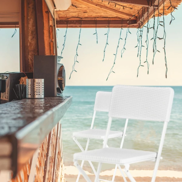 Bastian rattan hatású fehér színű kültéri bárszékek egy tengerparti nyaralóhely bárpultjánál 