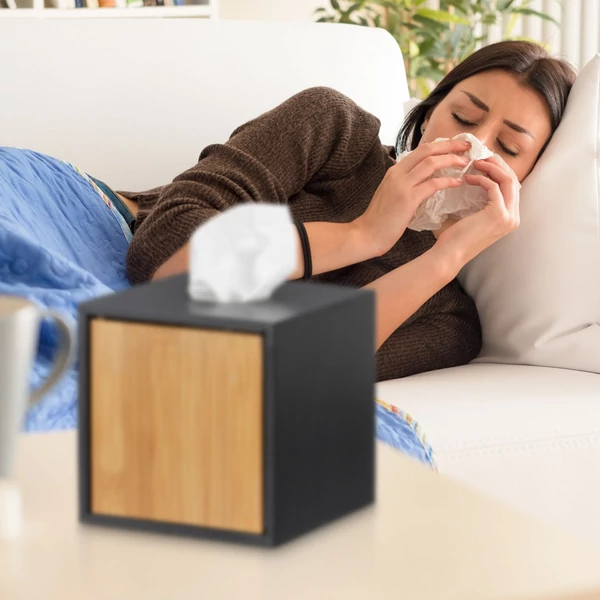 Fekete keretes bambusz betétes kozmetikai kendő és zsebkendő tartó doboz egy náthás hölggyel a háttérben