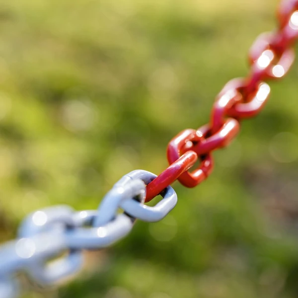 Piros-fehér színű műanyag összekötő lánc amellyel terelőoszlopokat behajtásgátló oszlopokat tudunk összekapcsolni