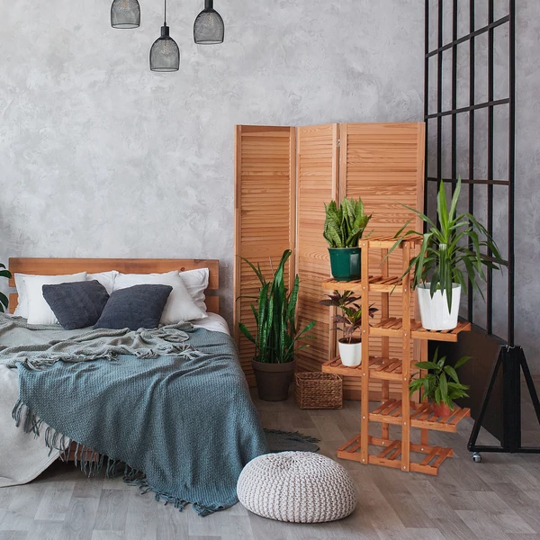 Gretel fenyő virágtartó állvány a hálószobában egy szintén fából készült paravá előtt az ágy mellett