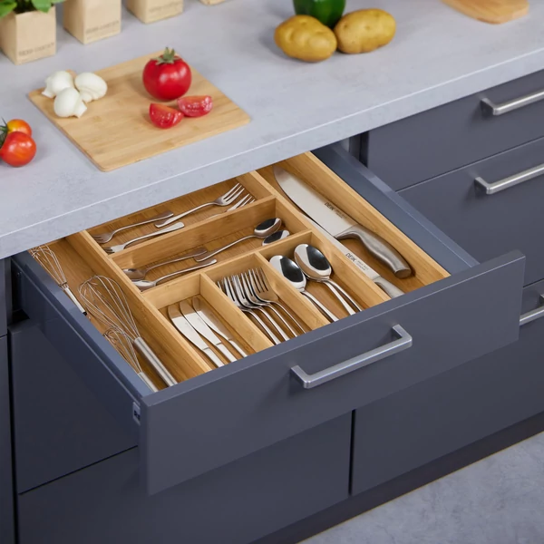 Állítható bambusz evőeszköztartó és fiókbetét rozsdamentes acél eszközökkel egy kék konyhszekrny fiókjában