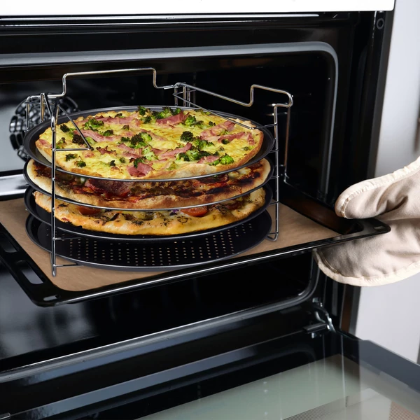 négy darab pizzasütő tálcát és egy darab acél állványt tartalmazó pizzakészítő készlet három darab éppen elkészült pizzával a sütőben