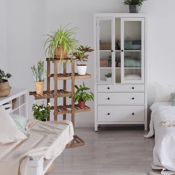 Sötétbarna színű gretel fenyőfa virágállvány a hálószobában különböző fehér színű fa bútorok között