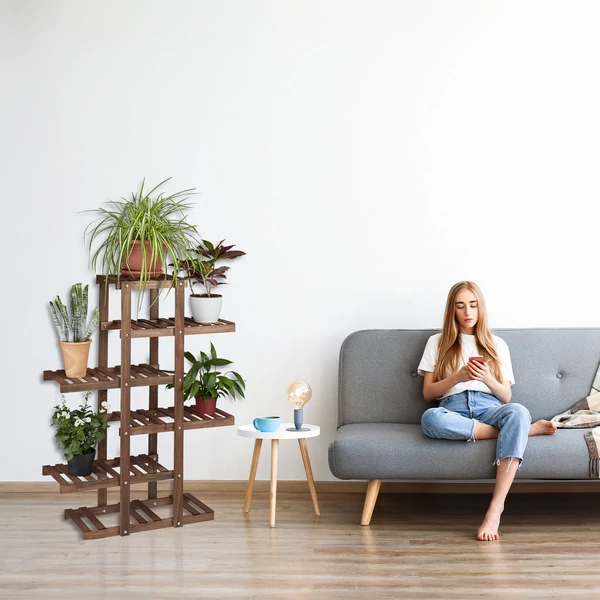 Gretel többszintes fenyőfa virágtartó állvány különféle cserepes növényekkel a nappaliban a szürke kanapé mellett