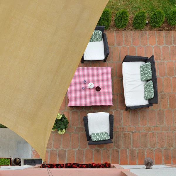 HDPE alapanyagból készült vastag homok színű napvitorla egy teraszrész felett kifeszítve