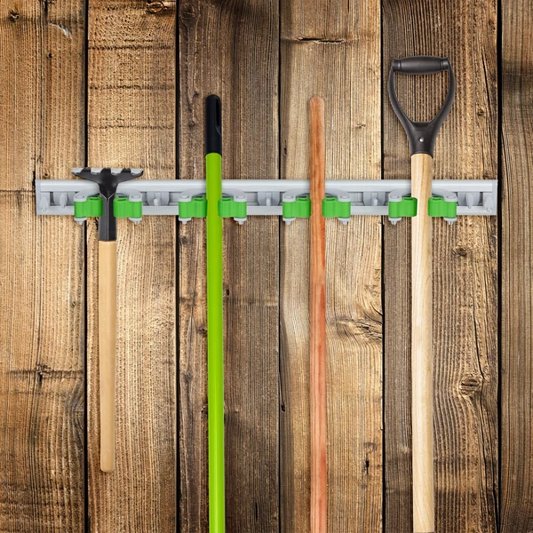 Fa kerítésre felszerelt fali kerti eszköz és szerszámtartó seprűvel ásóval és kapával