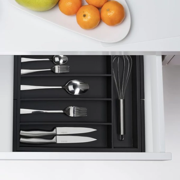 Fekete színű evőeszköztartó evőeszközökkel fehér konyhabútorban