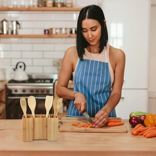 Főzési előkészületeket végző hölgy a bal oldalán egy banga összecsukható konyhai eszköz tartóval