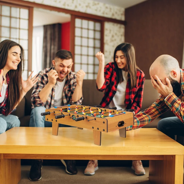 Asztali foci és csócsóasztal egy baráti társaság kezelésében játék közben