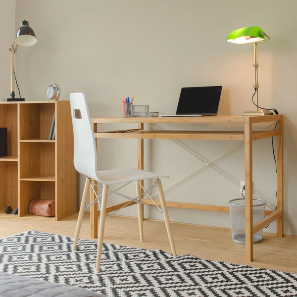 A nappali egyik sarkában elhelyezett nagyméretű bambusz írósztal és számítógépasztal laptoppal és minimal design székkel