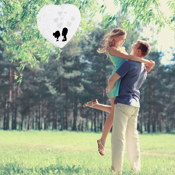 Szerelemes pár a háttérben egy szív formájú fehér pinatával