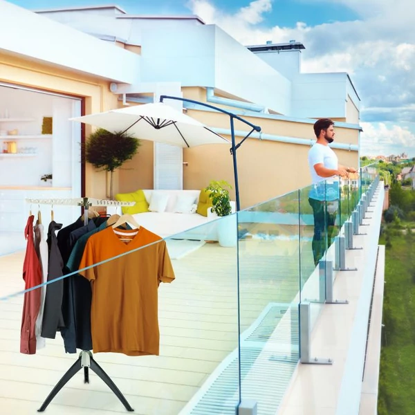 Nagyméretű teraszon kültéren elhelyezett száradó ruhák egy összecsukható ruhaszárító állványon