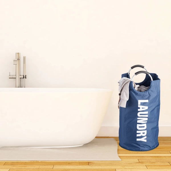 Kék színű masszív szövésű textil szennyeszsák 60 liter űrtartalommal a fürdőkád mellett 