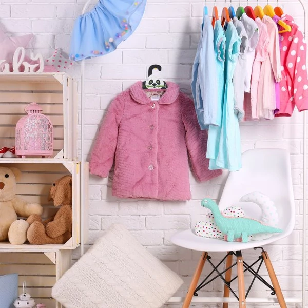 Panda mintás gyerek vállfákon egy fali akasztón elhelyezett kislány ruhadarabok