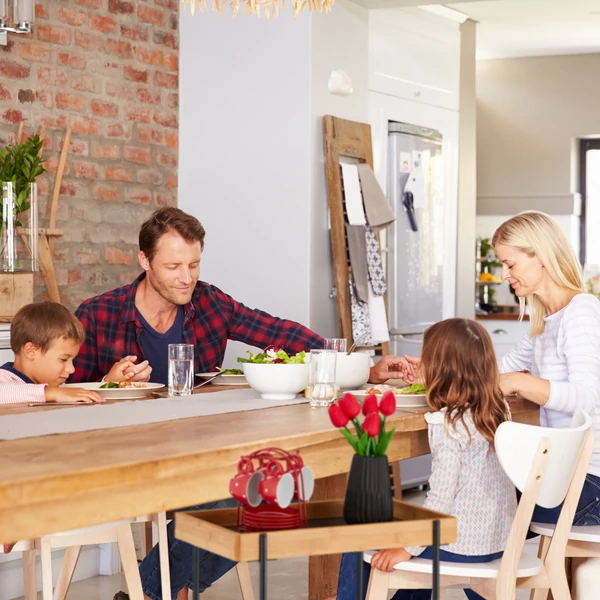 Logra bambusz polcos acélvázas zsúrkocsi és tálalókocsi az étkezőasztal mellett ahol egy család fogyasztja el éppen az ebédet