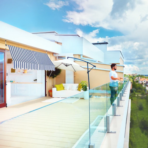 Penthouse lakás erkélyére szerelt kék-fehér csíkos ejtőkaros árnyékoló