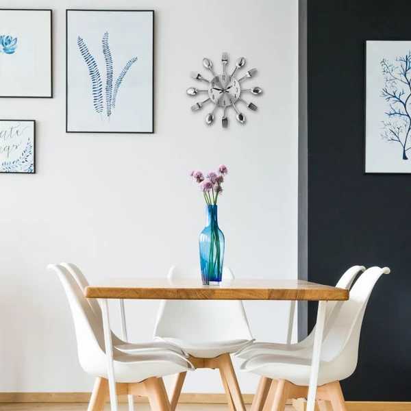 Étkezőben az étkező garnitúra felett elhelyezett késekből és villákból álló falióra képkeretek között