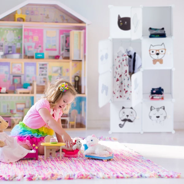 Kislány szobája rózsaszín nagyméretű babaházzal és a mellette elhelyezet variálható gyerekszobai szekrénnyel