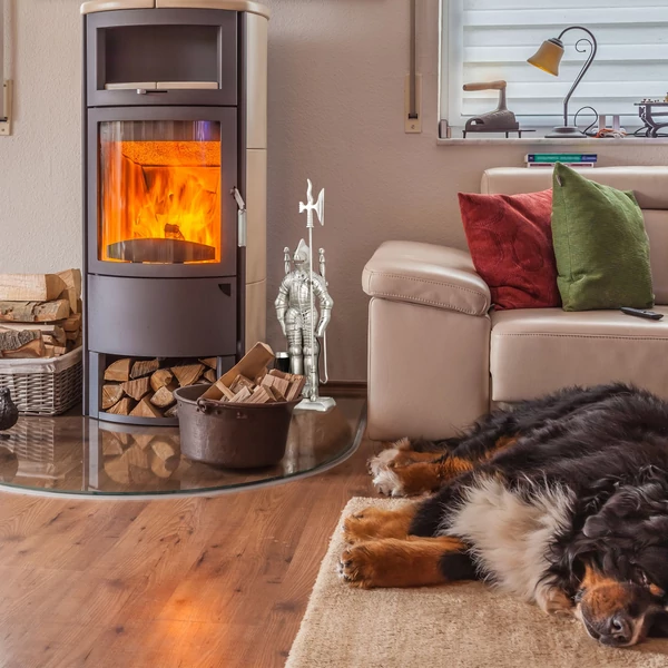 Nappaliban egy kör alakú kandalló mellett elhelyezett ezüst színű acélból készült lovag mintájú kandalló tisztító készlet