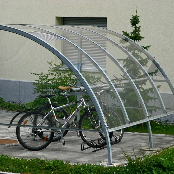 5 állásos fekete színű acél kültéri kerékpártároló egy fedett szerkezett alatt 2 db rajta elhelyezett biciklivel