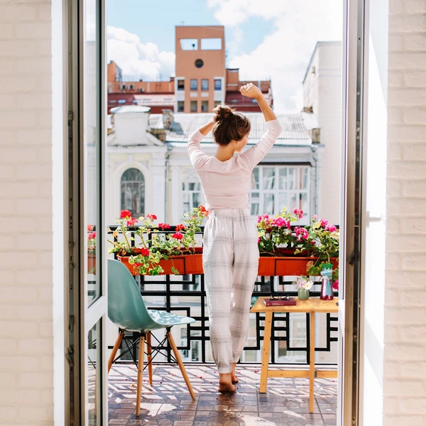 Belvárosi erkély színes székekkel és egy azon elhelyezett kisméretű és helytakarékos ahatu fa erkélyasztallal