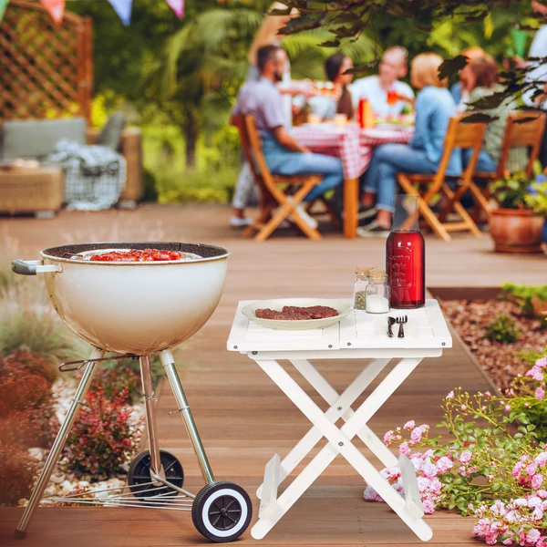 Kertben a grill mellett elhelyezett jakra összecsukható fa asztal fehér színben