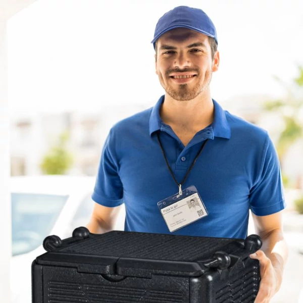 Ételkiszállító srác kék pólóban kezében egy fekete thermobox-szal