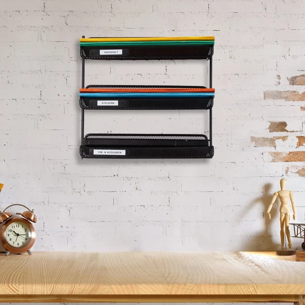 Hadna fekete színű íróasztal felett a falra szerelt fémből készült irattartó felcímkézhető fronttal