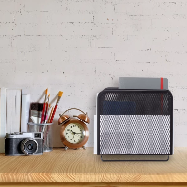 Fekete színű fémhálós pető íróasztali iratrendező az asztal jobb oldalán