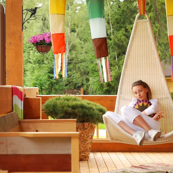 Szép fából készült teraszborítás a falra felszerelt madárka mintás akasztós cseréptartóval