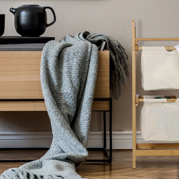 Zora natúr bambusz szennyestartó állvány tetején polccal és két darab kivehető textil szennyeszsákkal a hálószobában egy komód mellett